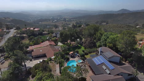 Aerial-of-luxurious-real-estate-with-swimming-pool-and-solar-panel,-top-of-hill