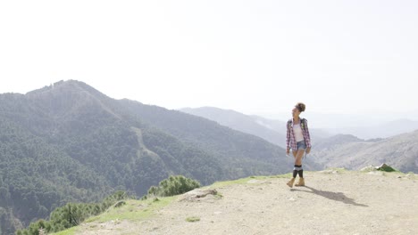 女人背包客在山顶上行走