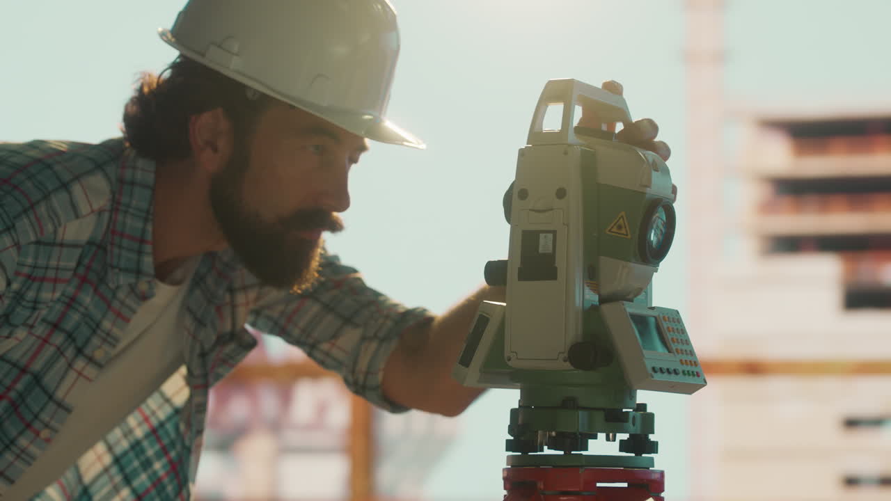 A surveyor using a total station on a construction site