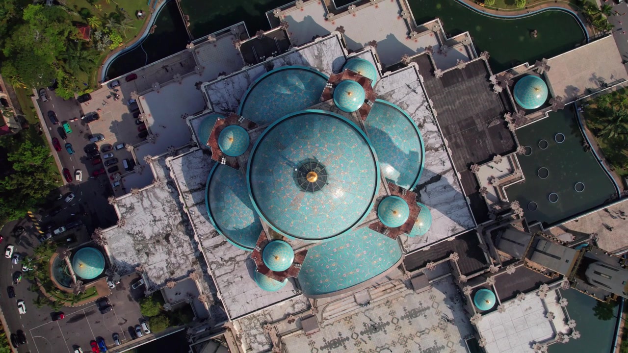 Rising rotating drone footage capturing the intricate blue domes of Masjid Wilayah from directly overhead in Kuala Lumpur, Malaysia.