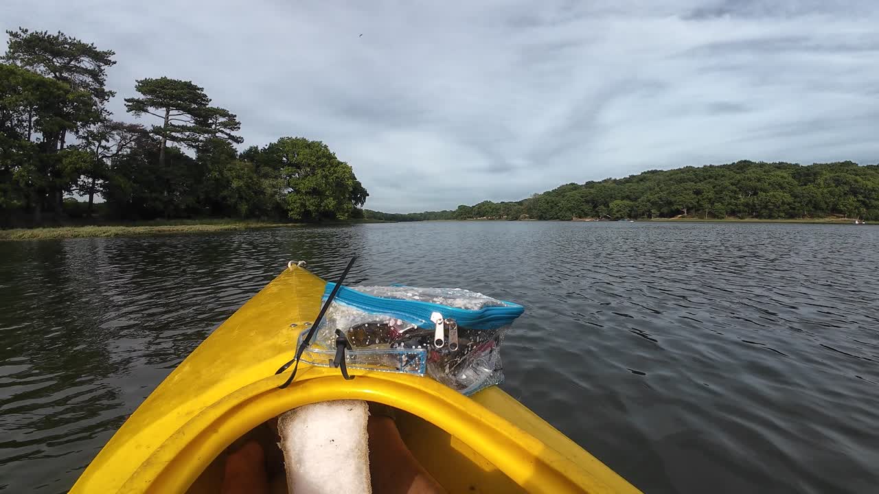 Tranquil kayaking on River Hamble in Southampton, England. Vibrant kayak foreground, lush greenery, dynamic clouds under soft light, wide-angle view captures serene outdoor beauty