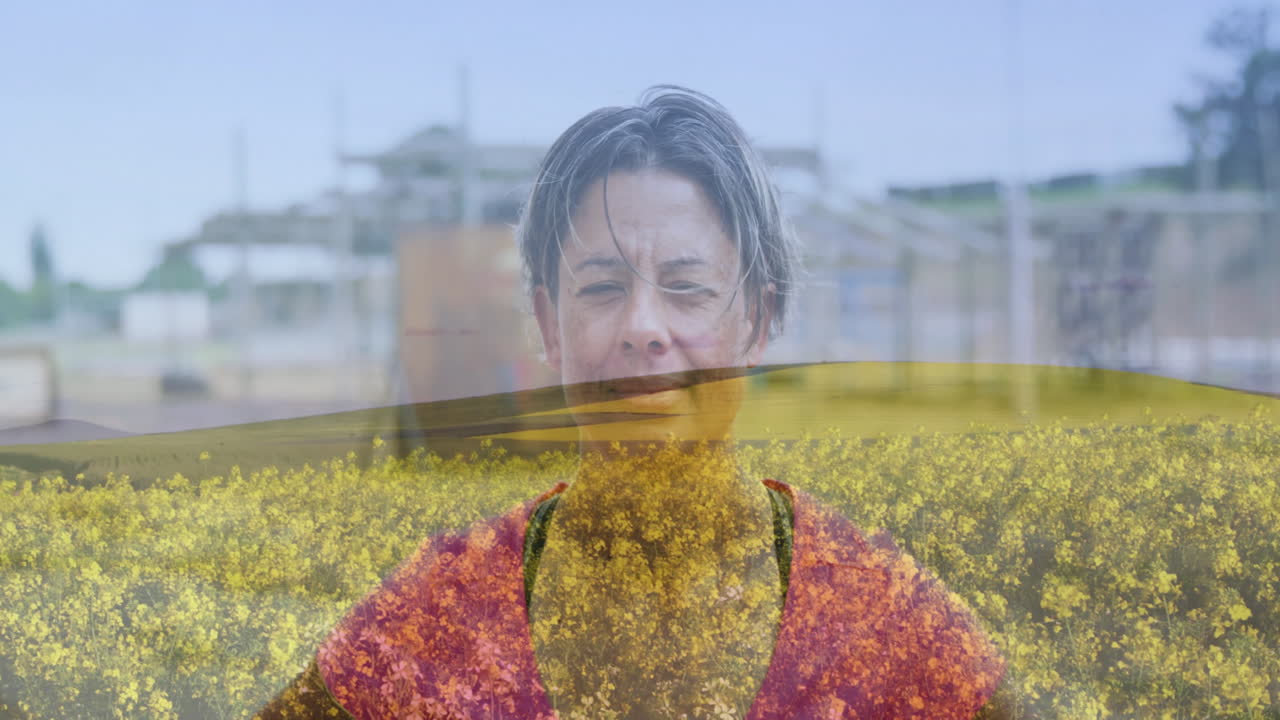 Standing in field of yellow flowers, woman with animation of buildings in background