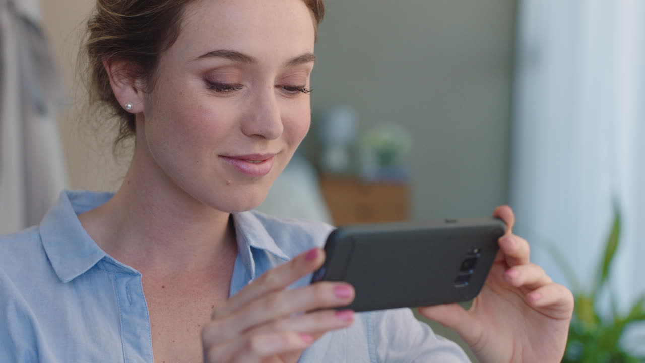 mujer hermosa usando un teléfono inteligente viendo entretenimiento en línea leyendo mensajes de redes sociales relajándose en casa disfrutando de la tecnología móvil