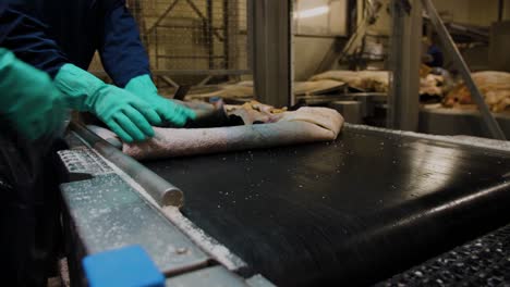 man flipping leather sheets over in a factory