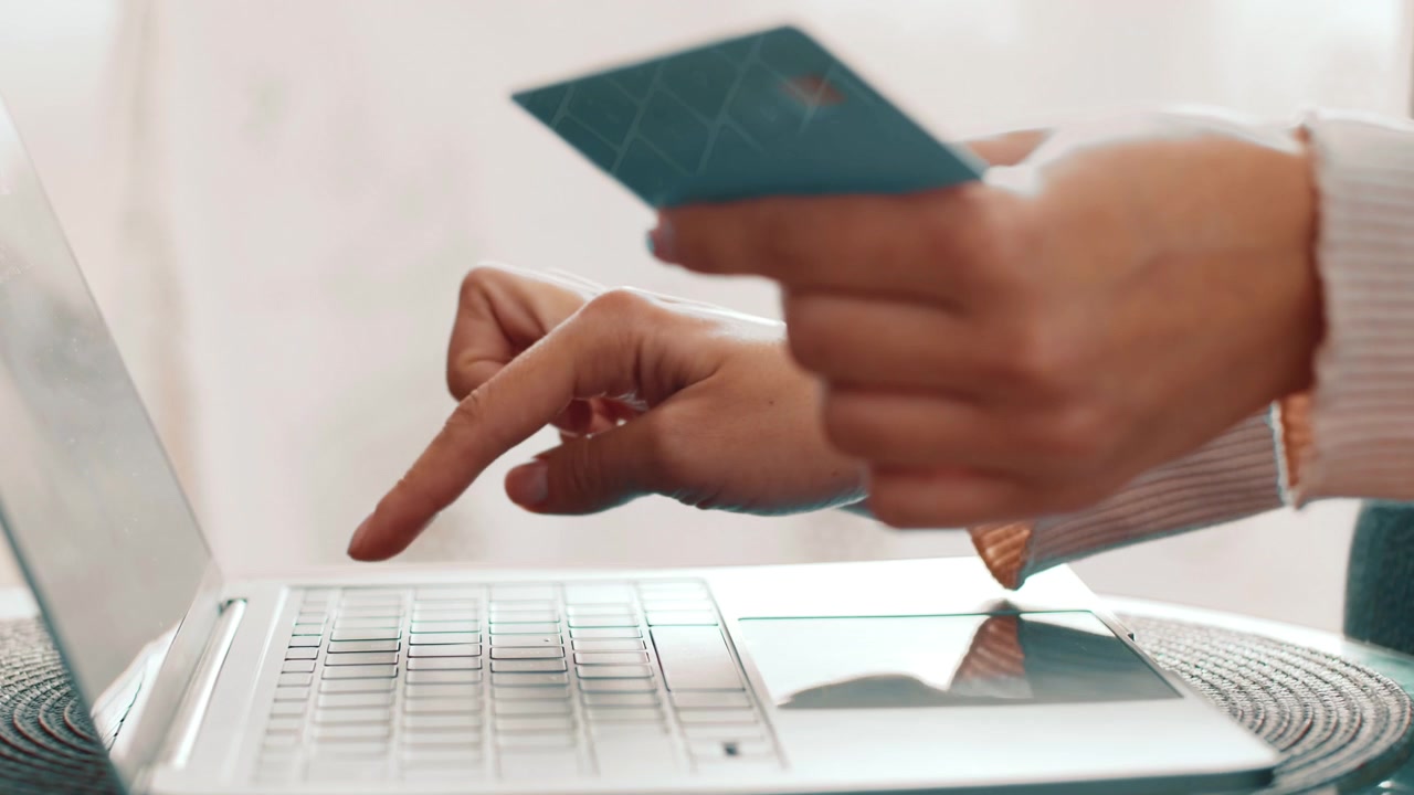 Woman Making Online Purchase with Credit Card on Laptop
