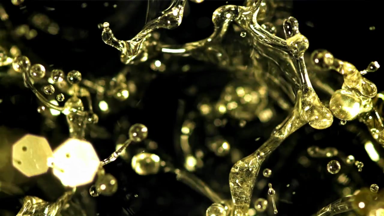Abstract Golden Liquid Droplets Flowing and Merging in Slow Motion
