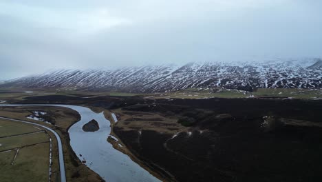 Meandering-River-in-Broad-Valley-with-Snow-Capped-Mountains-AERIAL