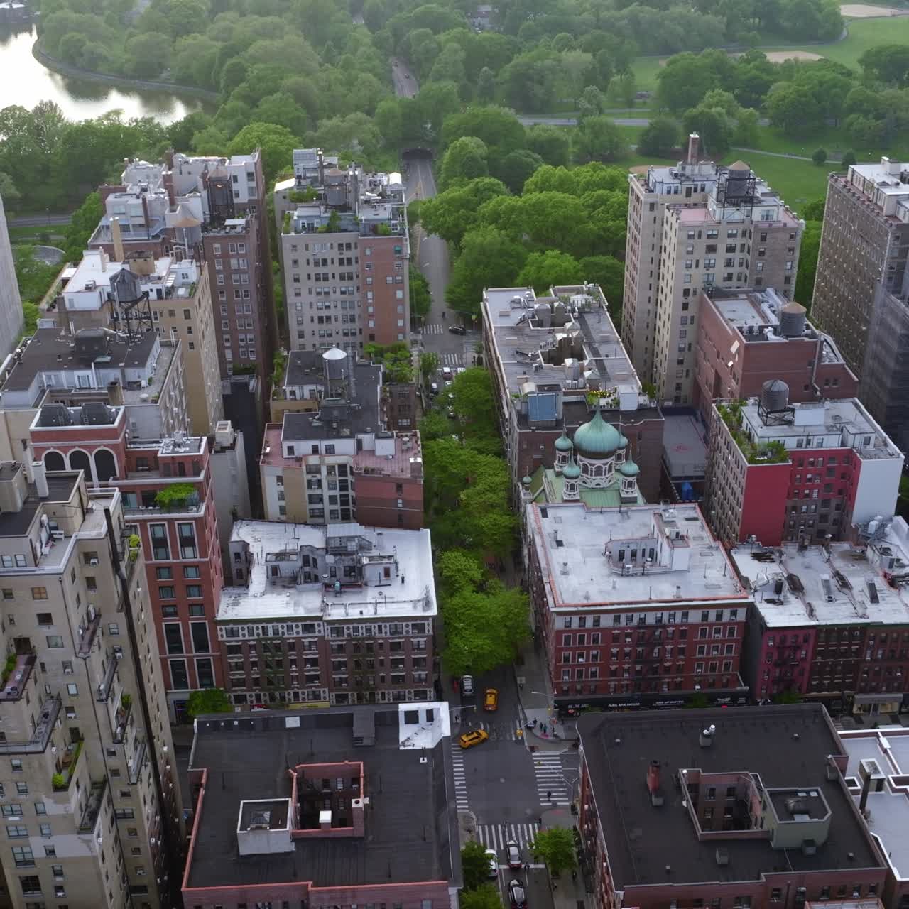 Residential area with diverse houses at daytime. Beautiful green park and river right behind the quarter. Aerial view