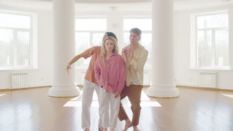 multiethnic group of contemporary dancers dancing in the middle of studio and looking at camera