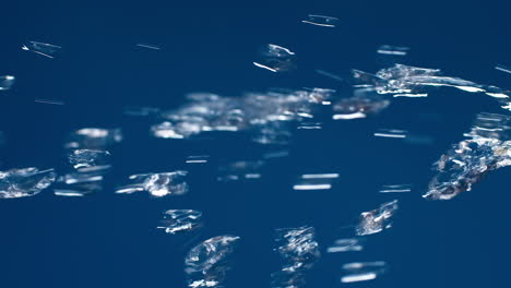 Vertical-of-Real-pure-water-flowing-down-with-splashing-on-blue-background-shooting-in-slow-motion