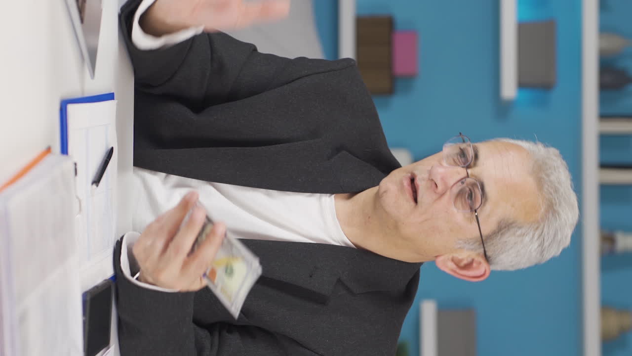 홈 오피스 직원 남자가 달러를 거래하는 수직 비디오.