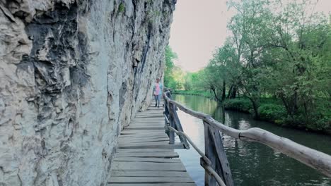 woman walks rocky escarpment boardwalk along eco trail zlatna panega river