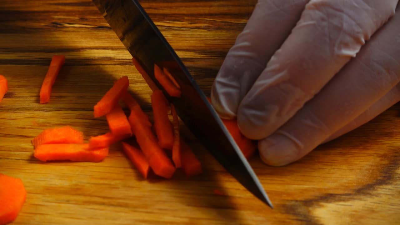 Il cuoco taglia carote su un tagliere