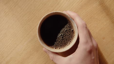 Top-Down-Shot-of-hot-coffee-in-a-mug-on-wooden-table-in-the-morning