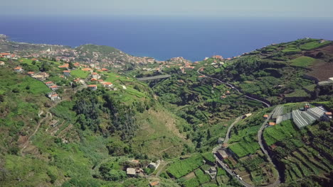 aerial panning down to terraced farming valley overlooking atlantic ocean