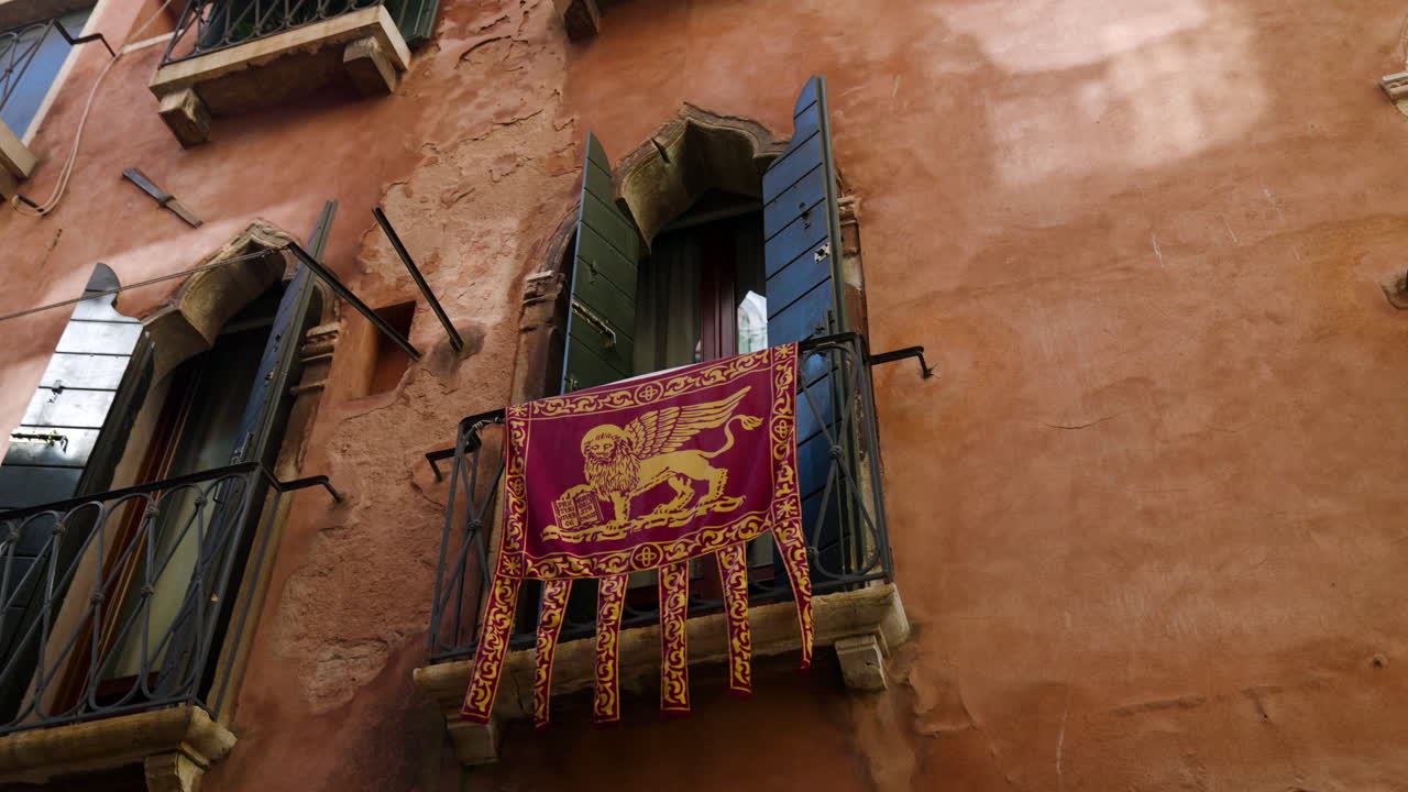 bandera de la república de venecia colgada en el balcón del casco antiguo de venecia, italia.