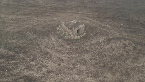 old hermitage of sant esteban in ruins in middle of arid field, aerial view