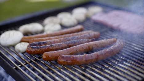 grilled sausages and mushrooms on a barbecue grill