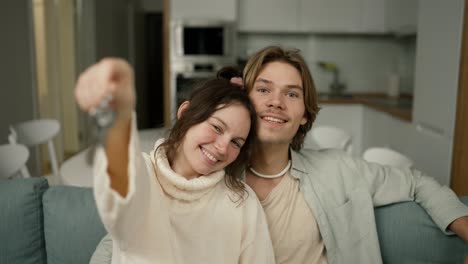 Blurred-footage-couple-in-living-room-show-keys-from-first-house