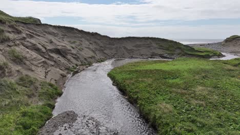 Aerial-Flyover-of-River-Revealing-Ocean