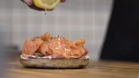 slow motion shot squeezing lemon onto bagel