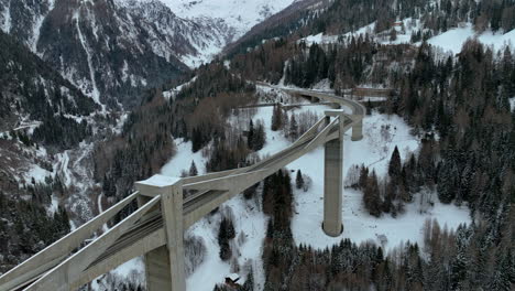 drone dolley shot of the ultra modern ganter bridge between the high swiss alps covered with white snow