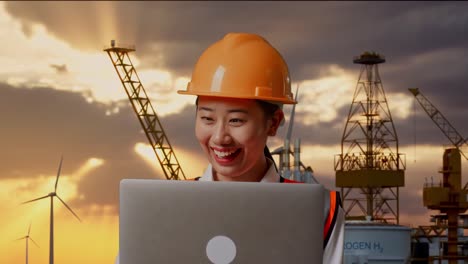ingeniero trabajando en una computadora portátil en una plataforma petrolera durante el atardecer