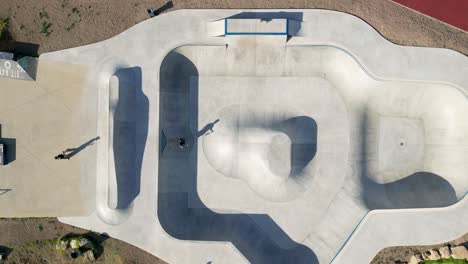 Top-down-aerial-view-of-skatepark-with-skaters-enjoying-the-park-during-sunset,-skate-PDG---Cascais