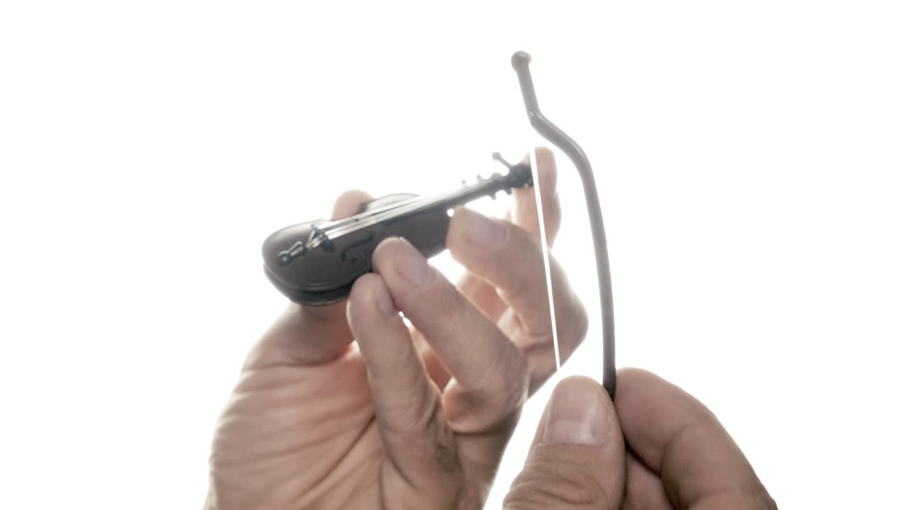 Playing the world's tiniest violin: a toy, symbol of irony, mocking others' grievances with its miniature melody. It conveys gentle mockery, suggesting life's absurdities.