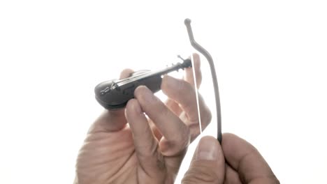 playing the world's tiniest violin: a toy, symbol of irony, mocking others' grievances with its miniature melody. it conveys gentle mockery, suggesting life's absurdities.
