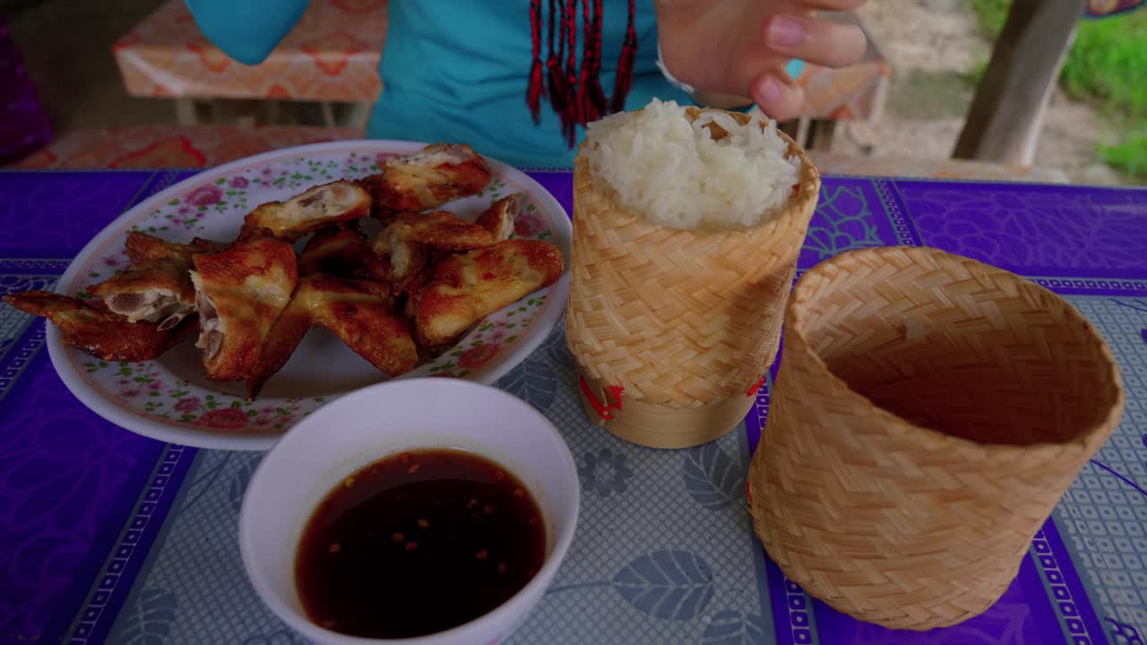 손 닭 날개와 흰 쌀로 먹는 사람의 클로즈업