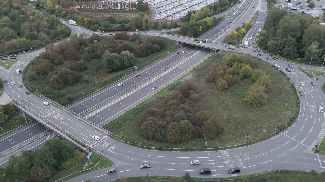 Orbital aerial view of traffic navigating the Gordano Interchange on the M5 motorway, surrounded by greenery, Bristol, UK, October 2024