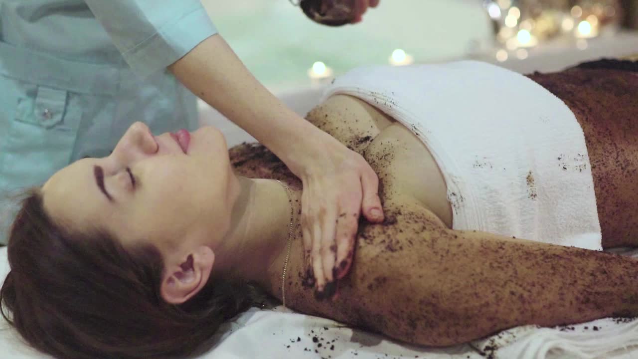 Kvinde får kaffescrub kropsbehandling i et spa