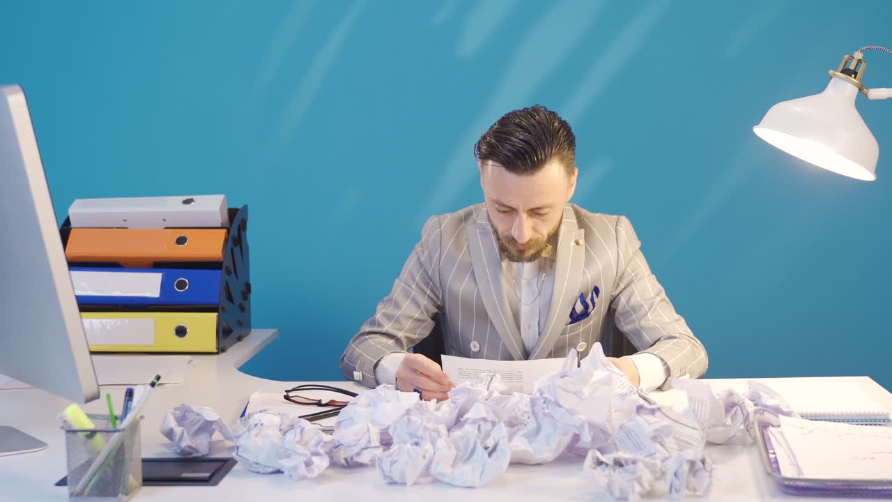 Frustrated businessman does not like the plans and actions and crumples the papers.