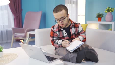 Male-student-with-dwarfism-listening-to-a-lecture-in-a-video-conference-questions-his-teacher.