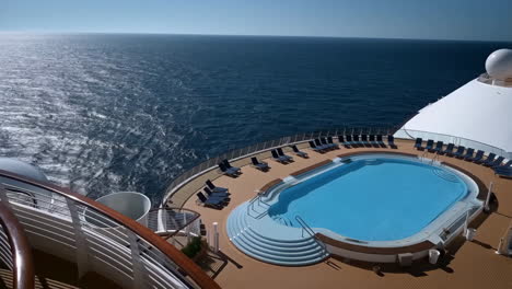 empty swimming pool on cruise ship deck overlooking the ocean