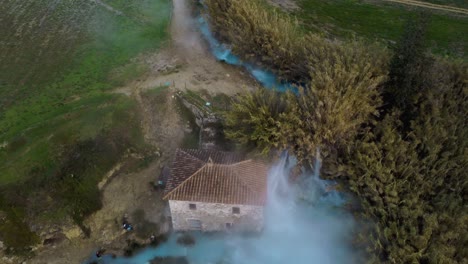 the geothermal hot springs bath and waterfall at saturnia, tuscany italy close to siena and grosseto at sunrise