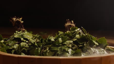 birch leaves in a wooden sauna bowl