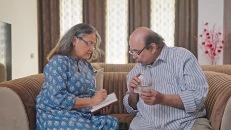 Old-Indian-couple-making-monthly-expense-report