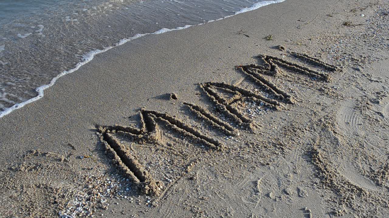 Indskriften "Miami" i sandet. Indskrift på sand