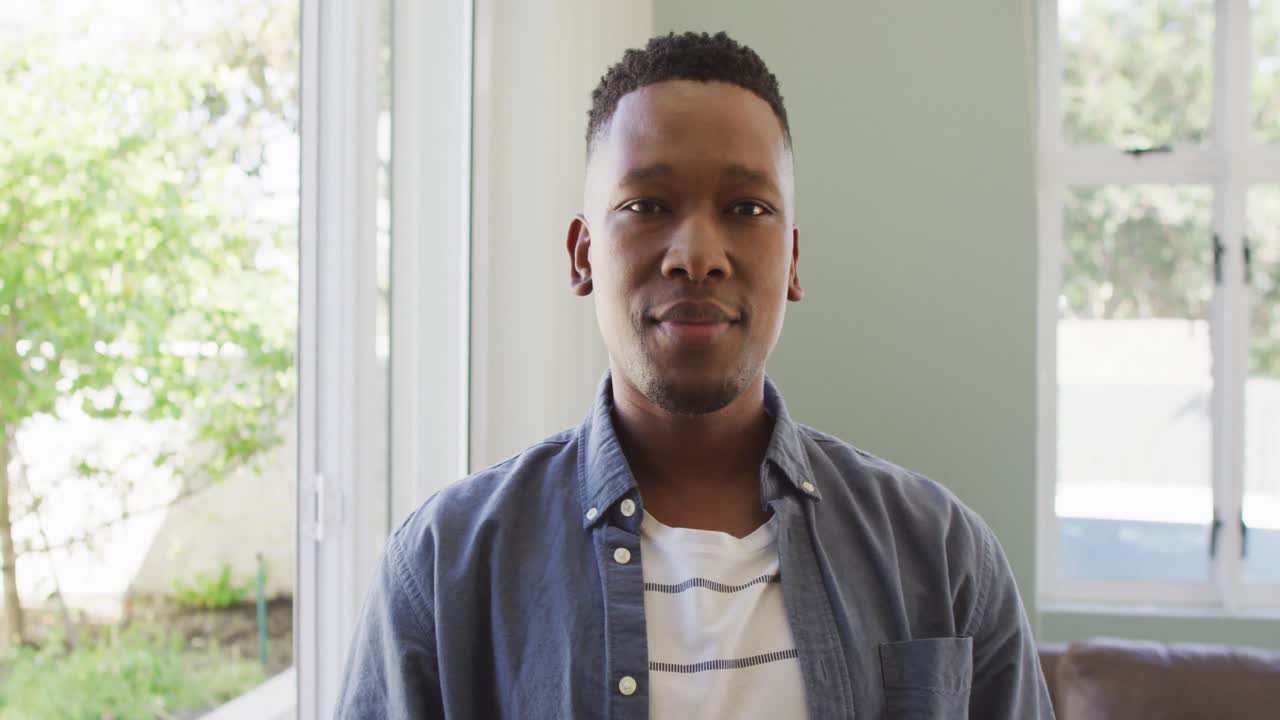 retrato de un feliz hombre afroamericano sonriendo en la sala de estar