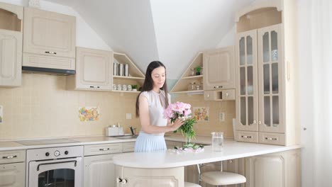woman arranging flowers in kitchen