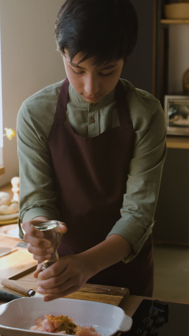 Teenage Boy Cooking Chicken in the Kitchen