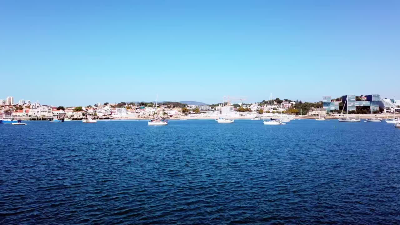 portugal, cascais, panorámica de tiempo que muestra la ciudad costera con veleros atracados