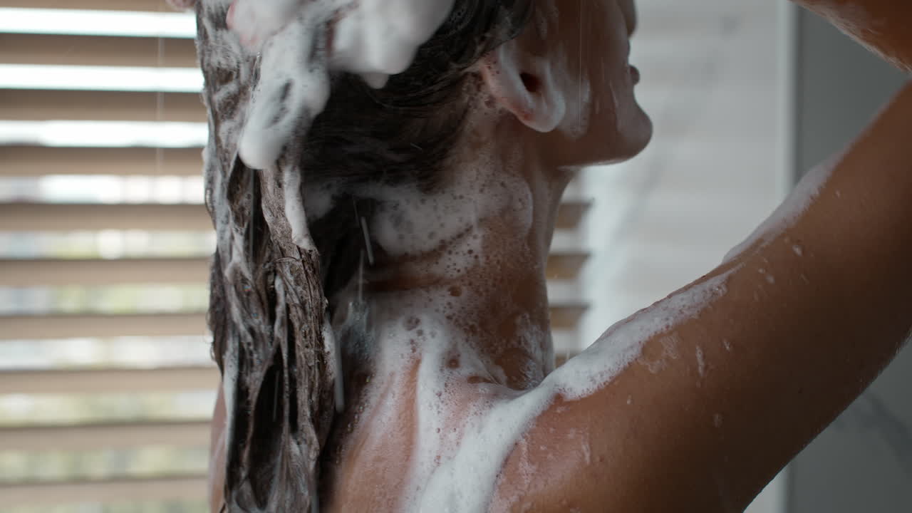 mujer lavándose el cabello en la ducha
