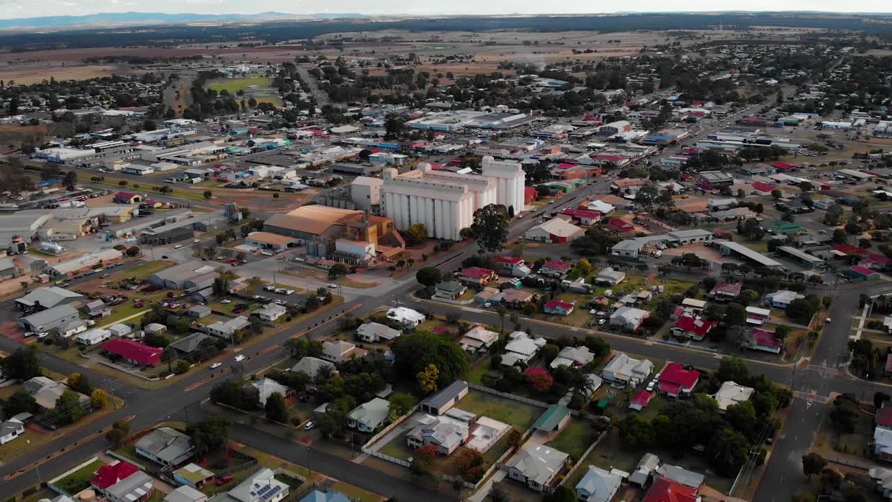 Aerial view away from the peanut silo, in the Kingaroy village, sunny morning, in Australia - pull back, drone shot