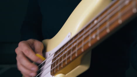 professional music teacher plays solo on white bass guitar