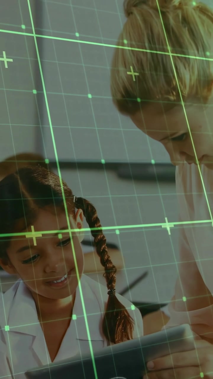 Vertical video: Teacher leaning over pupil, guiding tablet for class with green HUD aligning heads
