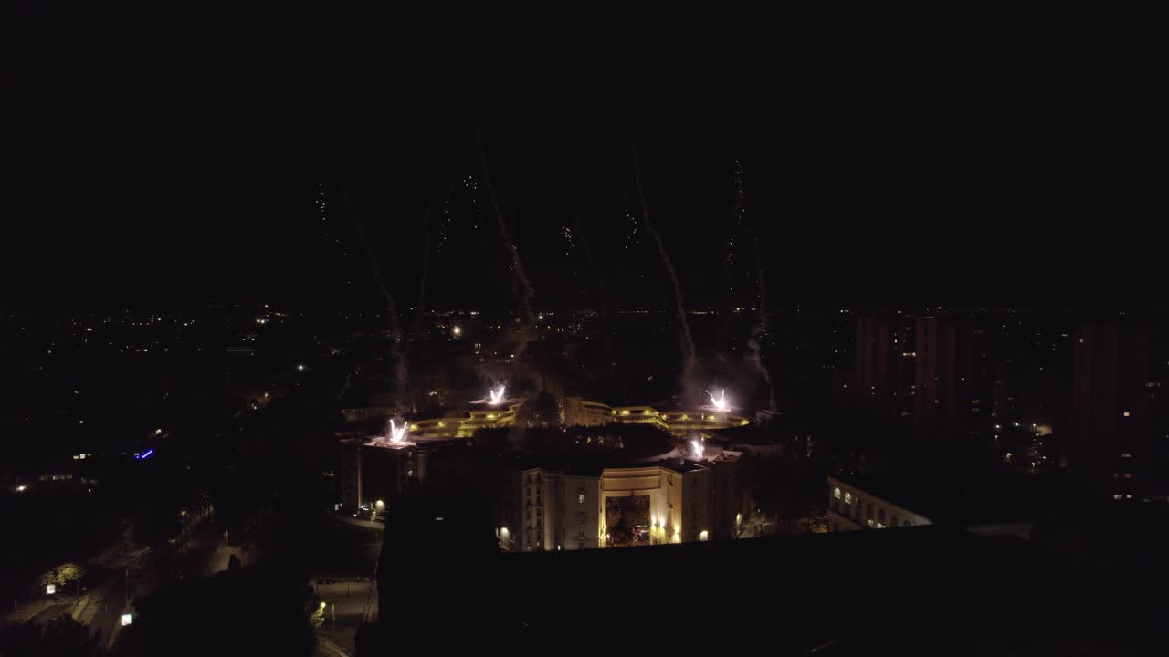 toma aérea de fuegos artificiales sobre un techo durante la noche en francia