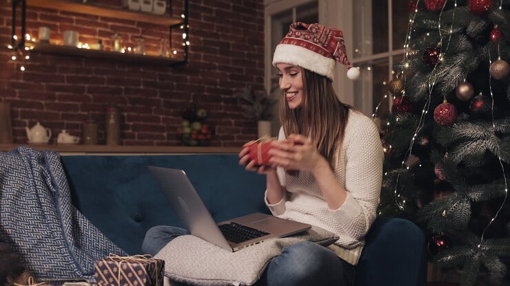 Woman celebrating Christmas with laptop and gifts